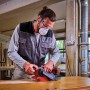 Einhell Akku-Bandschleifer TP-BS 18/457 Li BL Solo beim Schleifen von Holz.