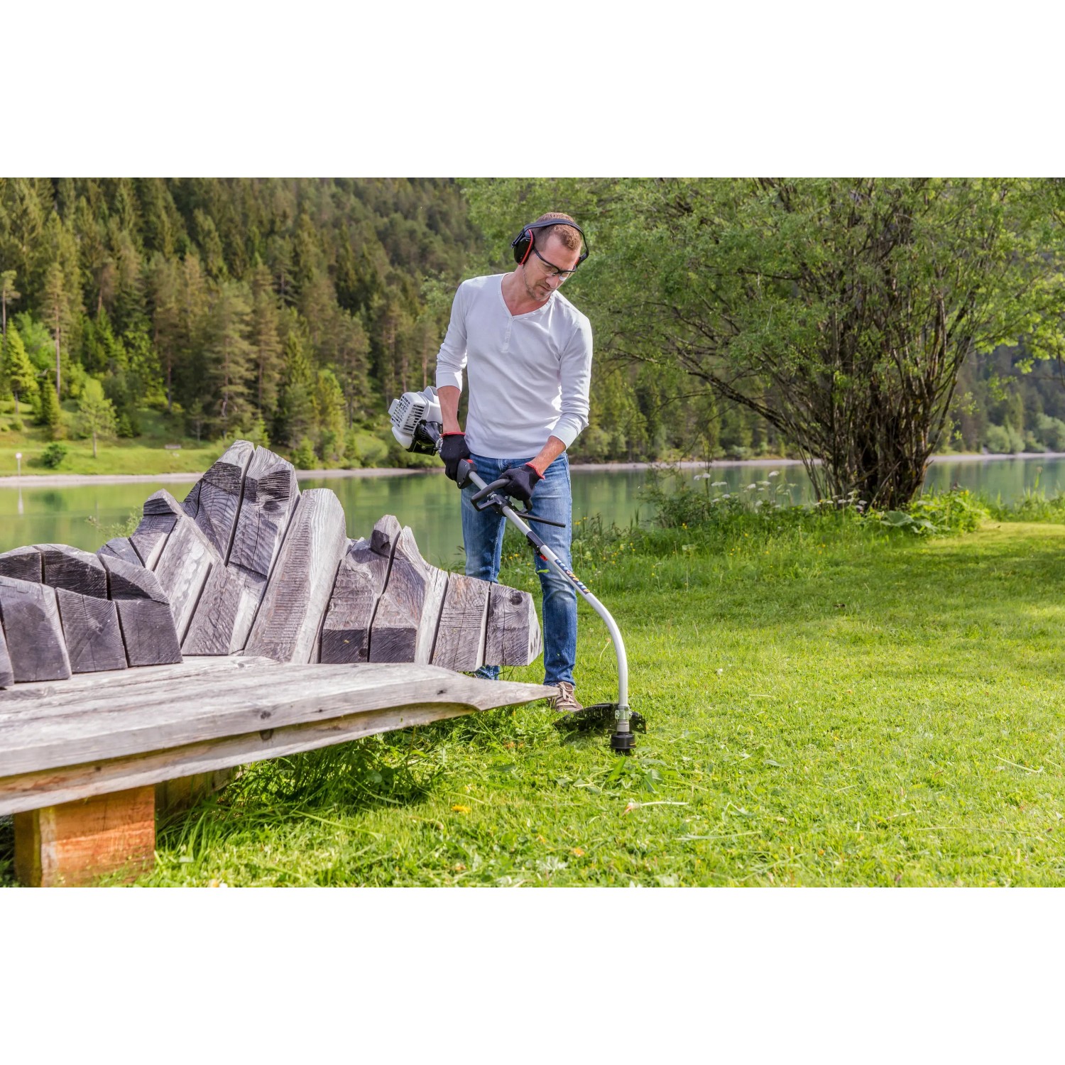 Mann arbeitet mit Al-Ko Benzinmotorsense BC 223 L-S im Garten am See.