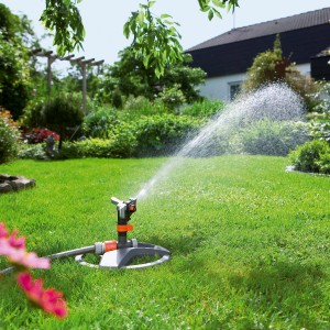 Gardena Premium Rasensprenger mit Schlitten bewässert Rasenfläche im Garten.