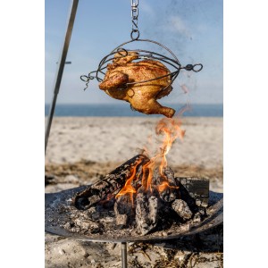 Petromax Dreibein Set: Grillhähnchen im Geflügel-Grillkorb über offenem Feuer.