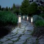4er-Set Solar-LED-Dekoleuchten Isili auf Gartenweg. Braune Leuchten mit tageslichtweißem Licht.