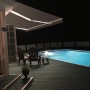 Graue Halbkassettenmarkise SUN LED, 300x200 cm, mit LED-Beleuchtung am Pool.