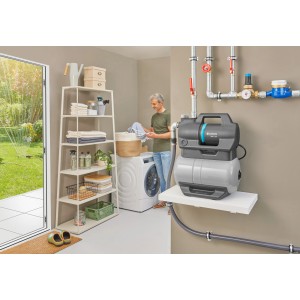 Gardena Hauswasserwerk 3900 Silent im Einsatz: Graue Pumpe mit Mann im Hintergrund in Waschküche.