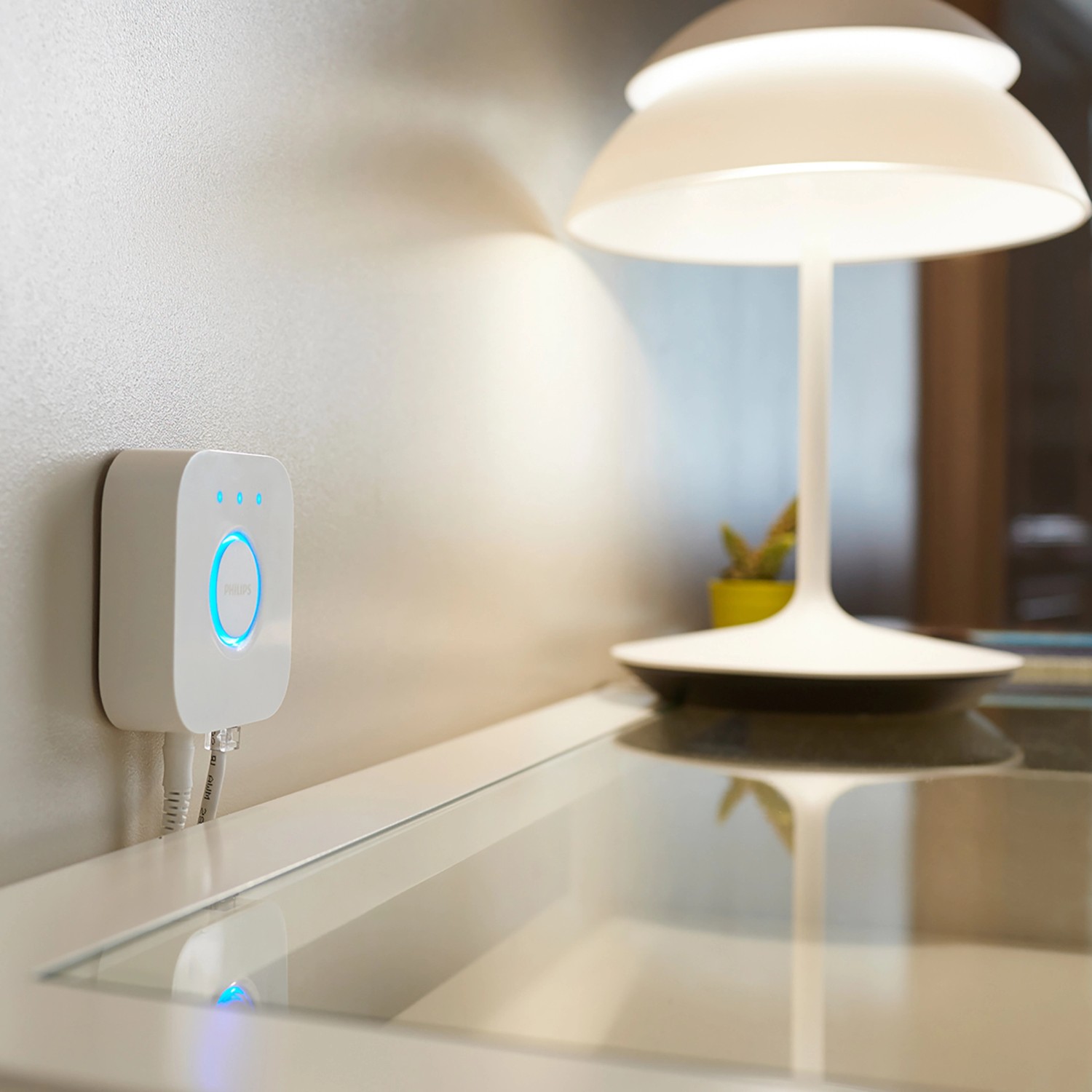 Philips Hue Bridge und Lampe des Starter-Sets auf einem Tisch, für smarte Lichtsteuerung.