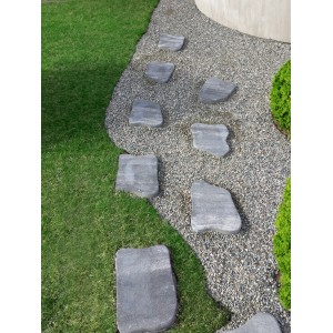 Anthrazit-graue Trittsteine als Gartenweg im Kies und Rasen, 35x25x5 cm.