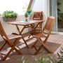Klappstuhl Greenville aus FSC®-Holz mit Gartentisch auf Balkon. Gartenstuhl platzsparend.