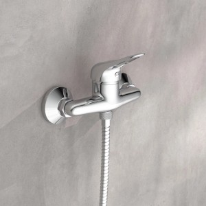 Schütte Duscharmatur Porto Chrom mit Brauseschlauch an grauer Wand.