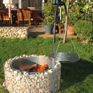 Bellissa Gabionen Grill- und Feuerstelle mit schwenkbarem Grillrost im Garten.