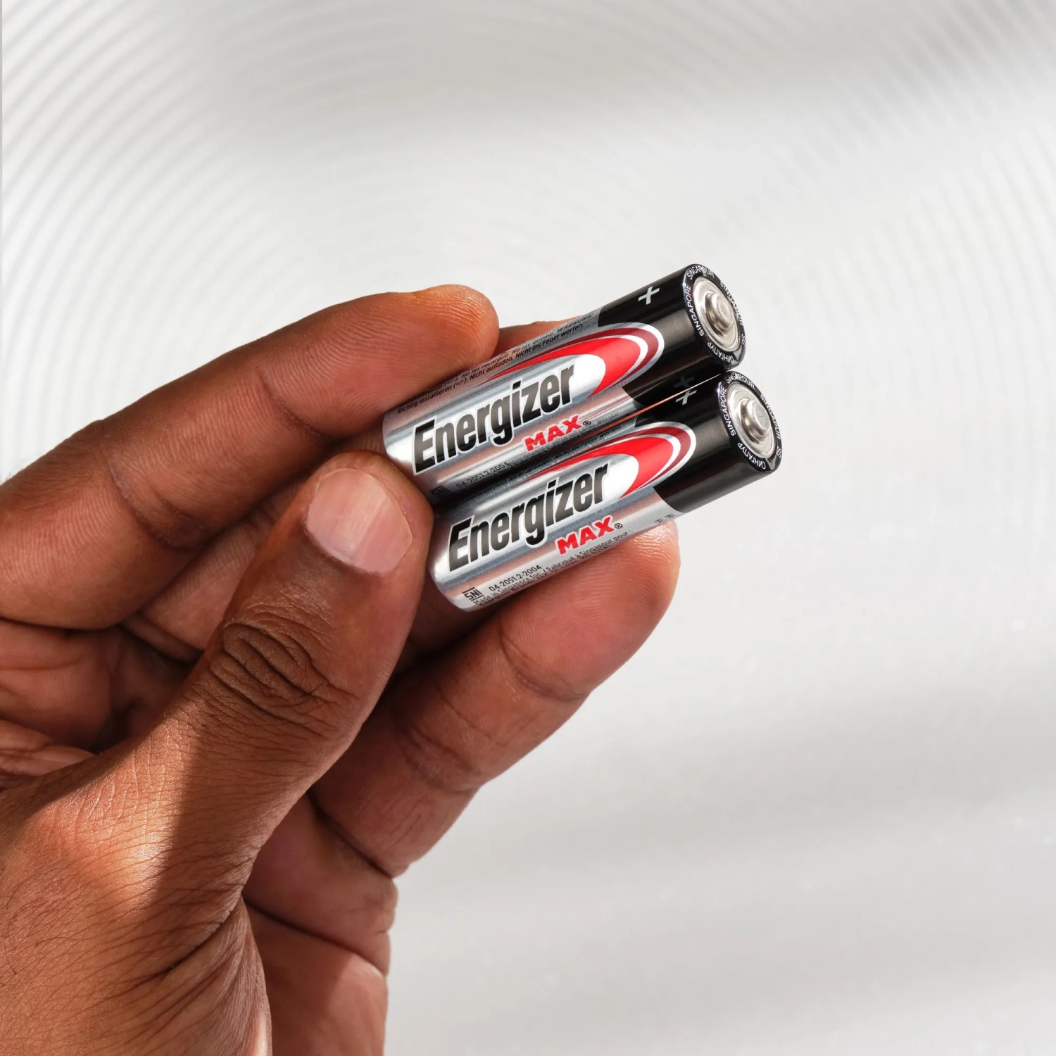Hand hält zwei Energizer Max AA Batterien. Alkali-Batterien für Geräte des täglichen Gebrauchs.