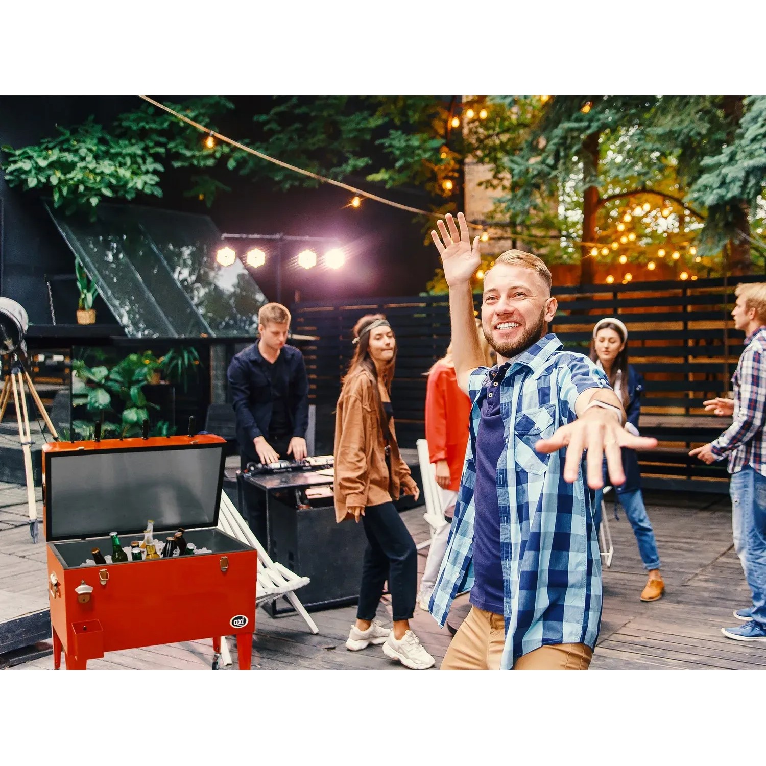Roter Axi Kühlwagen mit Tischfußball (65 l) auf einer Party mit feiernden Menschen.
