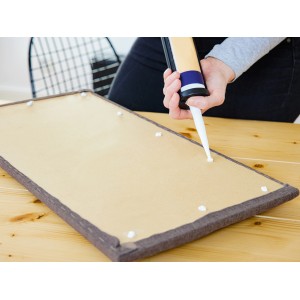 Montage des dunkelgrauen Wandkissens (60x30 cm) aus Samt mit Montagekleber.