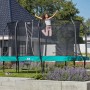 Grünes Salta First Class Gartentrampolin 366x214 cm mit Sicherheitsnetz und Leiter, springende Person.