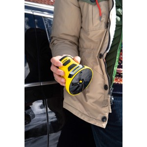 Gelber Kärcher EDI 4 Akku-Eiskratzer in Hand vor Auto. Praktischer Helfer für den Winter.