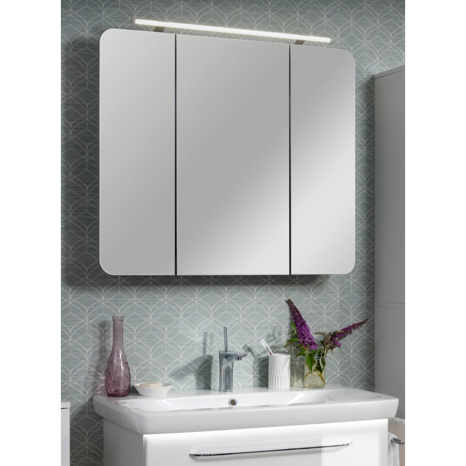 Fackelmann Spiegelschrank, 90 cm breit, weiß, mit drei Türen und Aufsatzleuchte über Waschbecken.