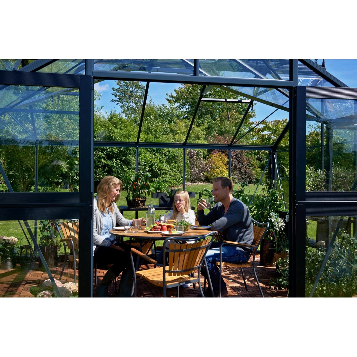 Juliana Gewächshaus Orangerie 15 in Schwarz-Anthrazit mit Familie beim Essen im Inneren.