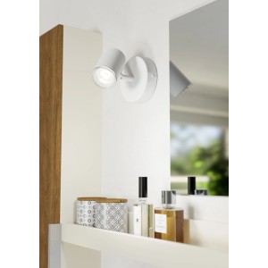 Weiße Eglo Consuma 1 Wandleuchte, drehbarer Spot, leuchtet an weißer Wand über Regal. IP44 Spritzwasserschutz für Bad, Flur.