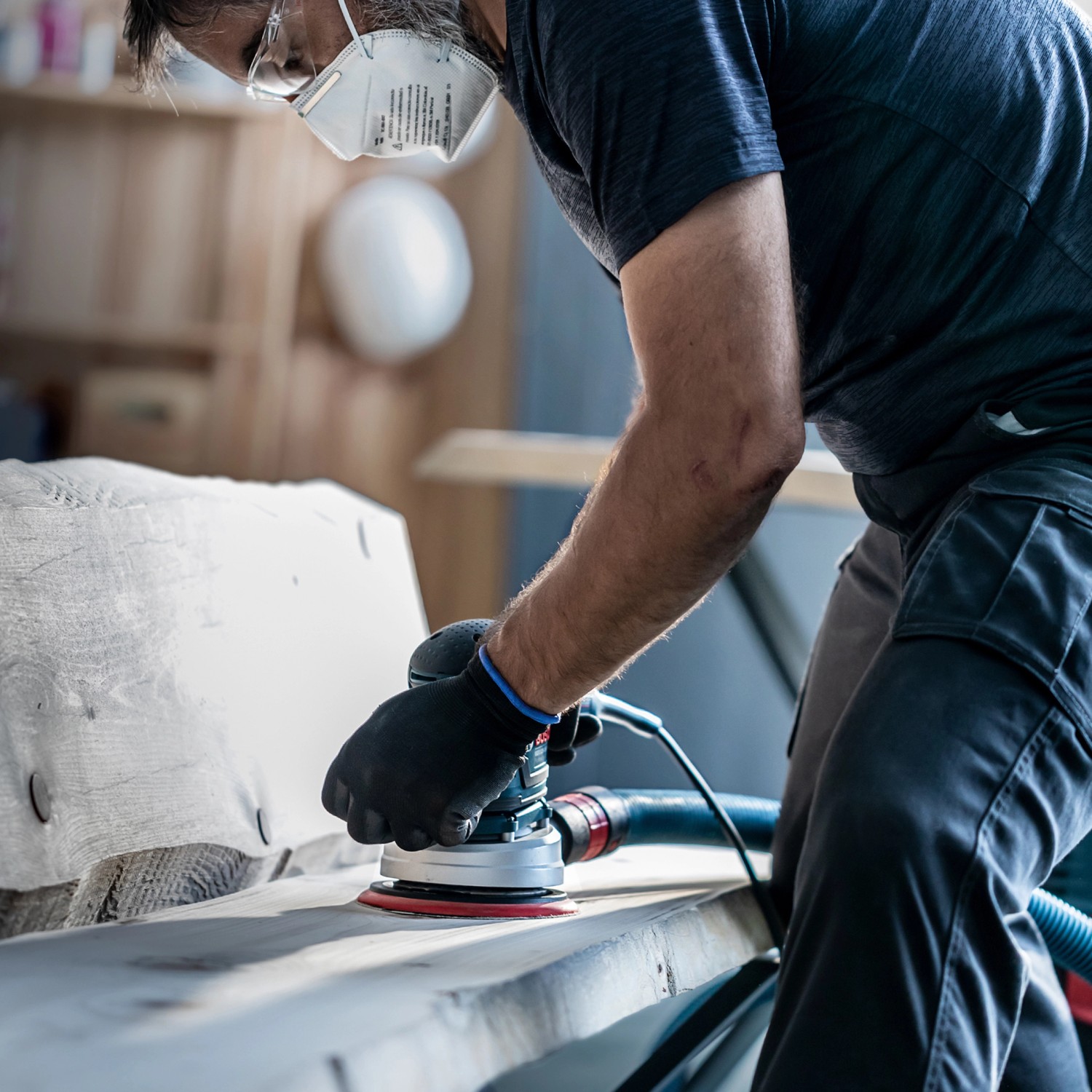 Anwender schleift Holz mit Bosch Exzenterschleifer und Expert Netzschleifblatt-Set.