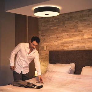 Schwarze Philips Hue Fair LED Deckenleuchte mit Dimmer in einem Schlafzimmer.