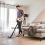 Mann saugt Teppich mit Kärcher Akku-Staubsauger VC 4 Cordless myHome.