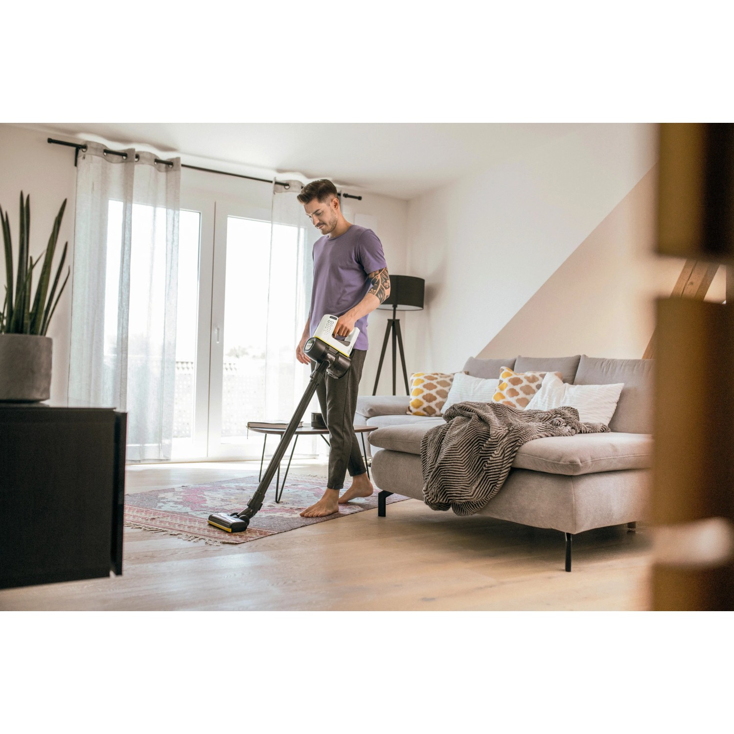 Mann saugt Teppich mit Kärcher Akku-Staubsauger VC 4 Cordless myHome.