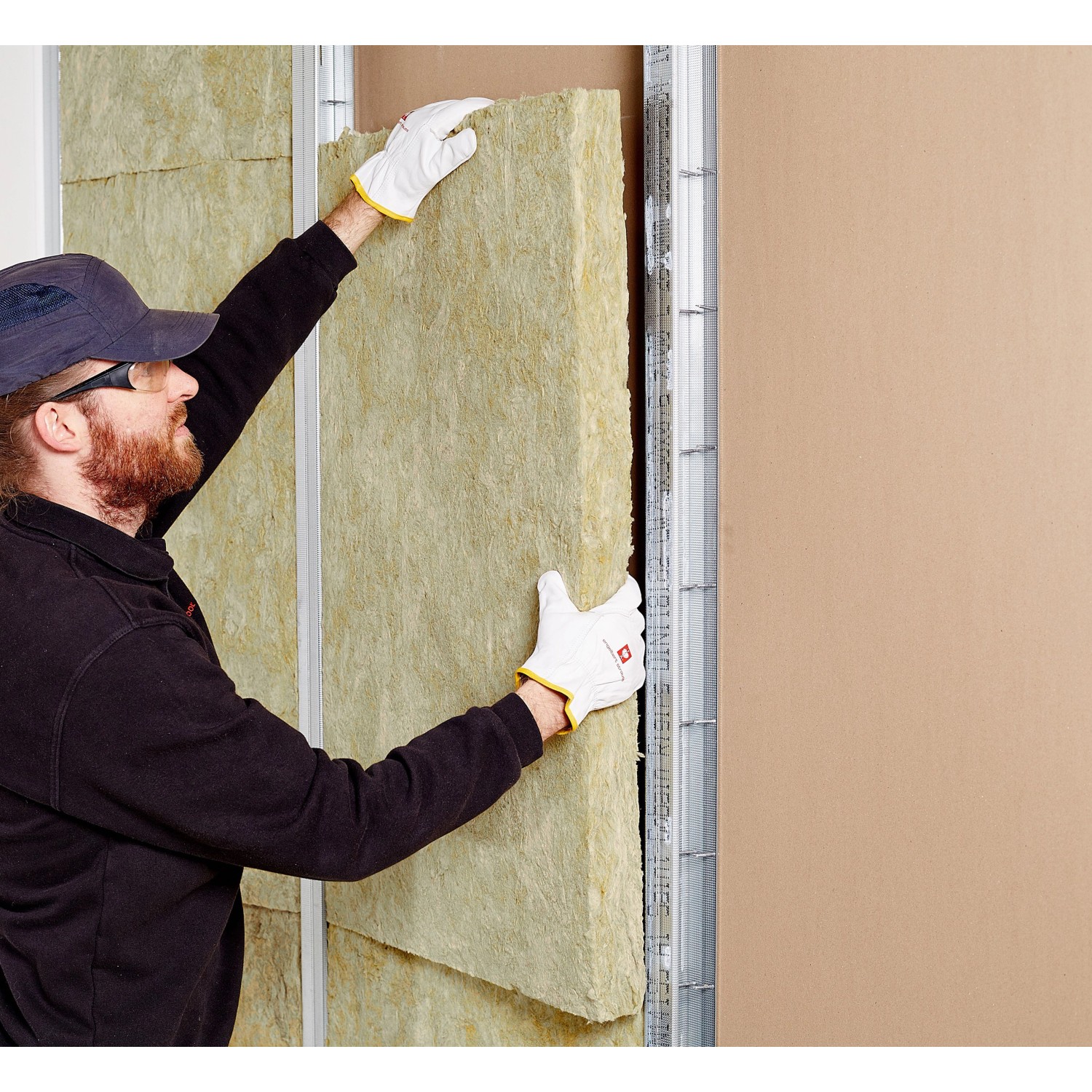 Handwerker montiert Rockwool Sonorock Trennwandplatte (40mm) aus Steinwolle zur Schall- und Wärmedämmung.