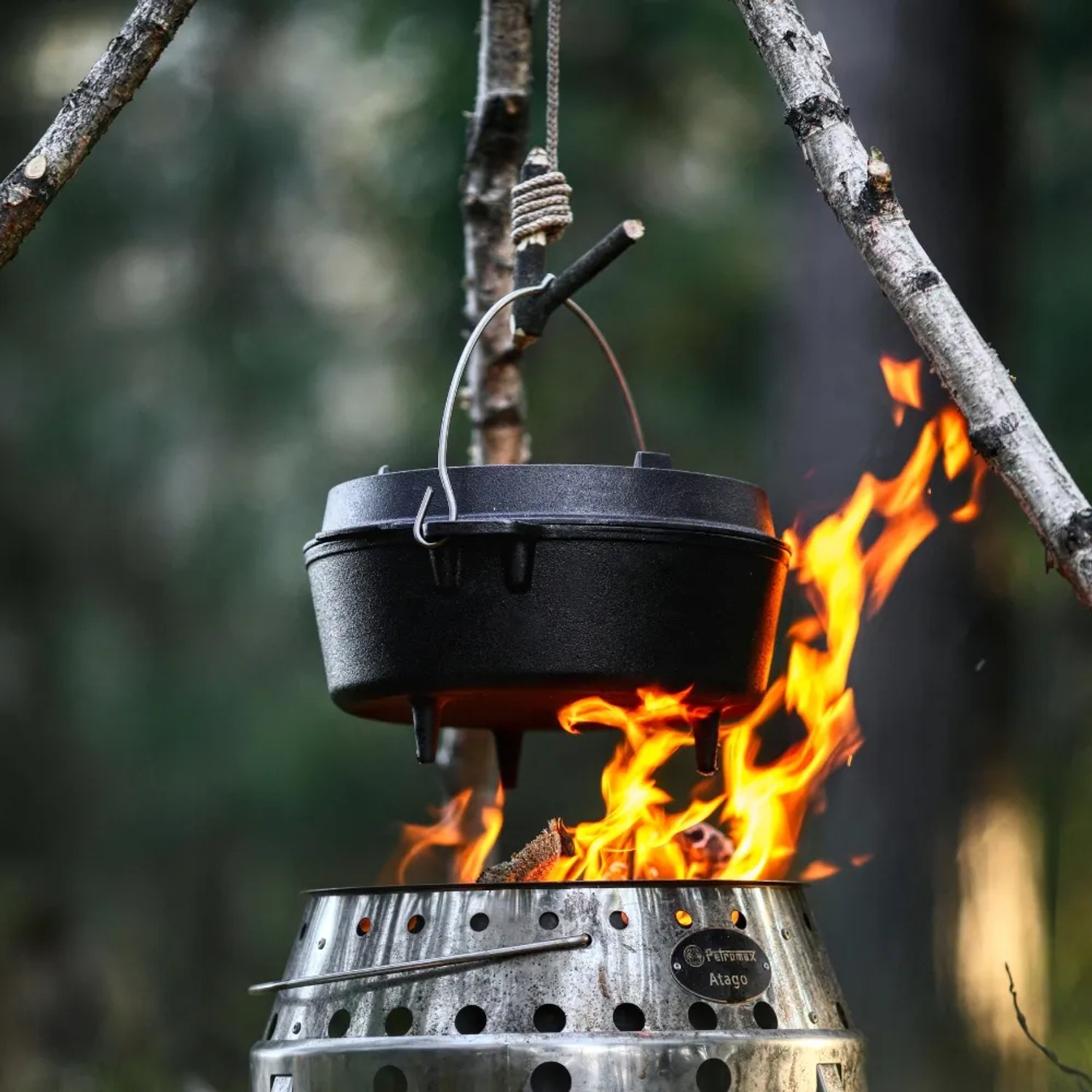 Schwarzer Petromax Dutch Oven FT9 (7,5 l) mit Füßen über offenem Feuer im Atago Grill.