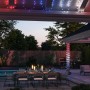 Philips Hue Festavia Lichterkette mit 250 LEDs in Rot, Weiß und Blau an einer Pergola.