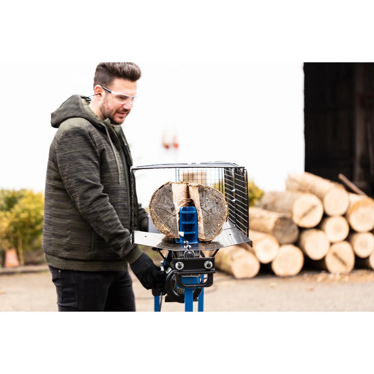 Scheppach Holzspalter HL760LS (7 t) im Einsatz mit Mann und Holzscheit.