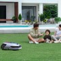 Dreame Mähroboter A2 2000 beim Rasenmähen vor einer Familie im Garten.