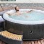 Mobiler aufblasbarer Whirlpool OTTOMAN im Rattan Design, Ø 204 cm, mit Person im Wasser.