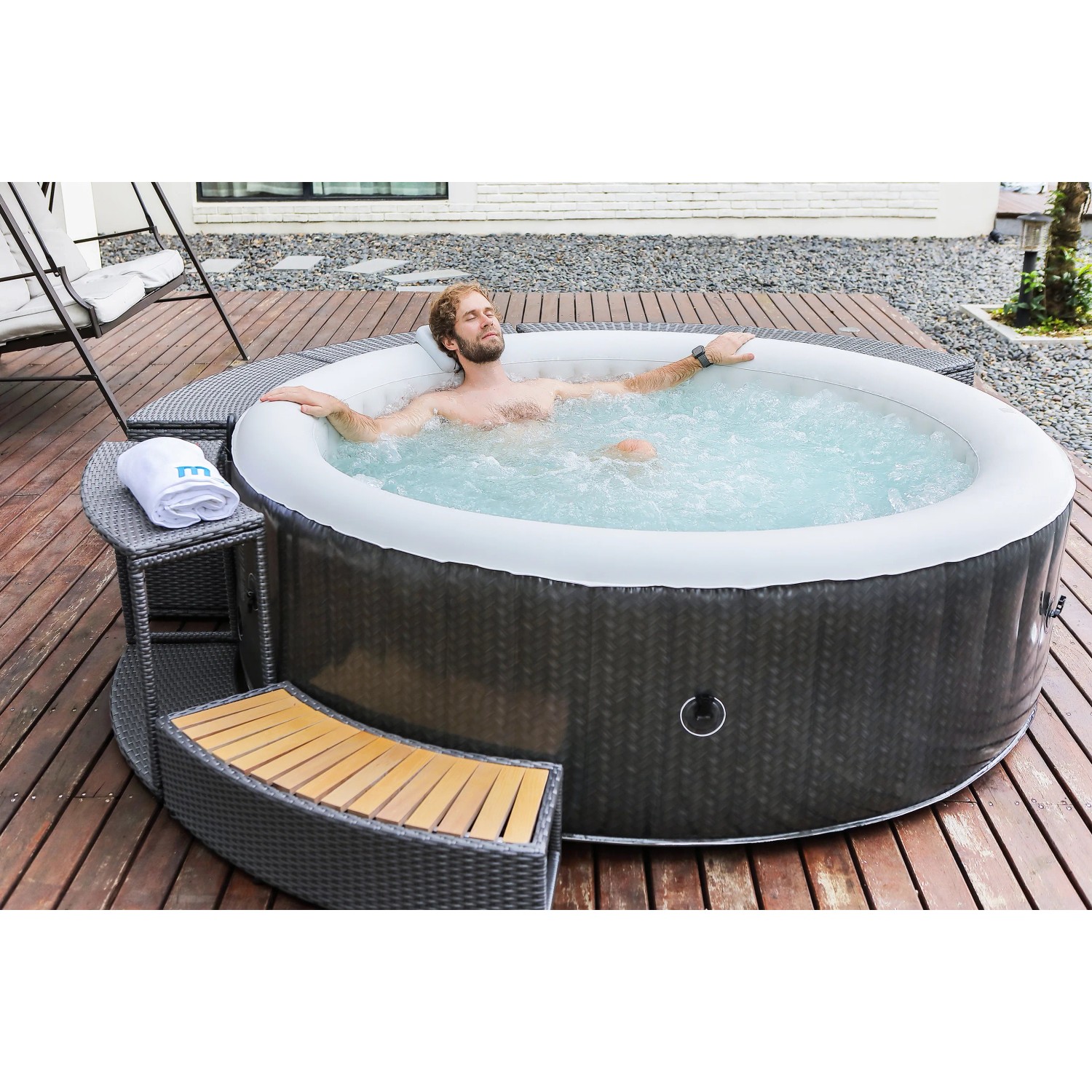 Mobiler aufblasbarer Whirlpool OTTOMAN im Rattan Design, Ø 204 cm, mit Person im Wasser.