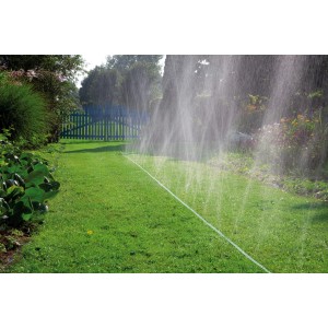 Gardena Schlauch-Regner 15m bewässert Rasenfläche im Garten mit feinem Sprühregen.