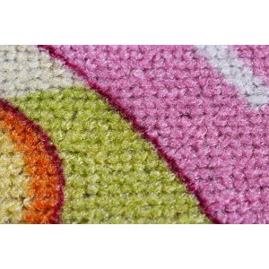 Detailaufnahme: Andiamo Kinderteppich Mono Pueblo mit pinken, grünen und orangen Farbakzenten.