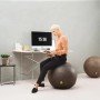 Brauner Sitting Ball Hocker Frankie (150 l) im Wohnraum mit Person.
