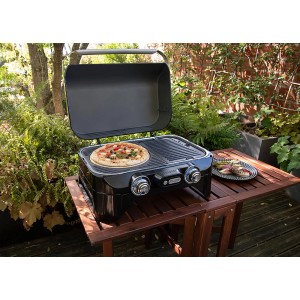 Campingaz Pizzastein auf Grill: Pizza backen mit Grillutensilien im Garten.