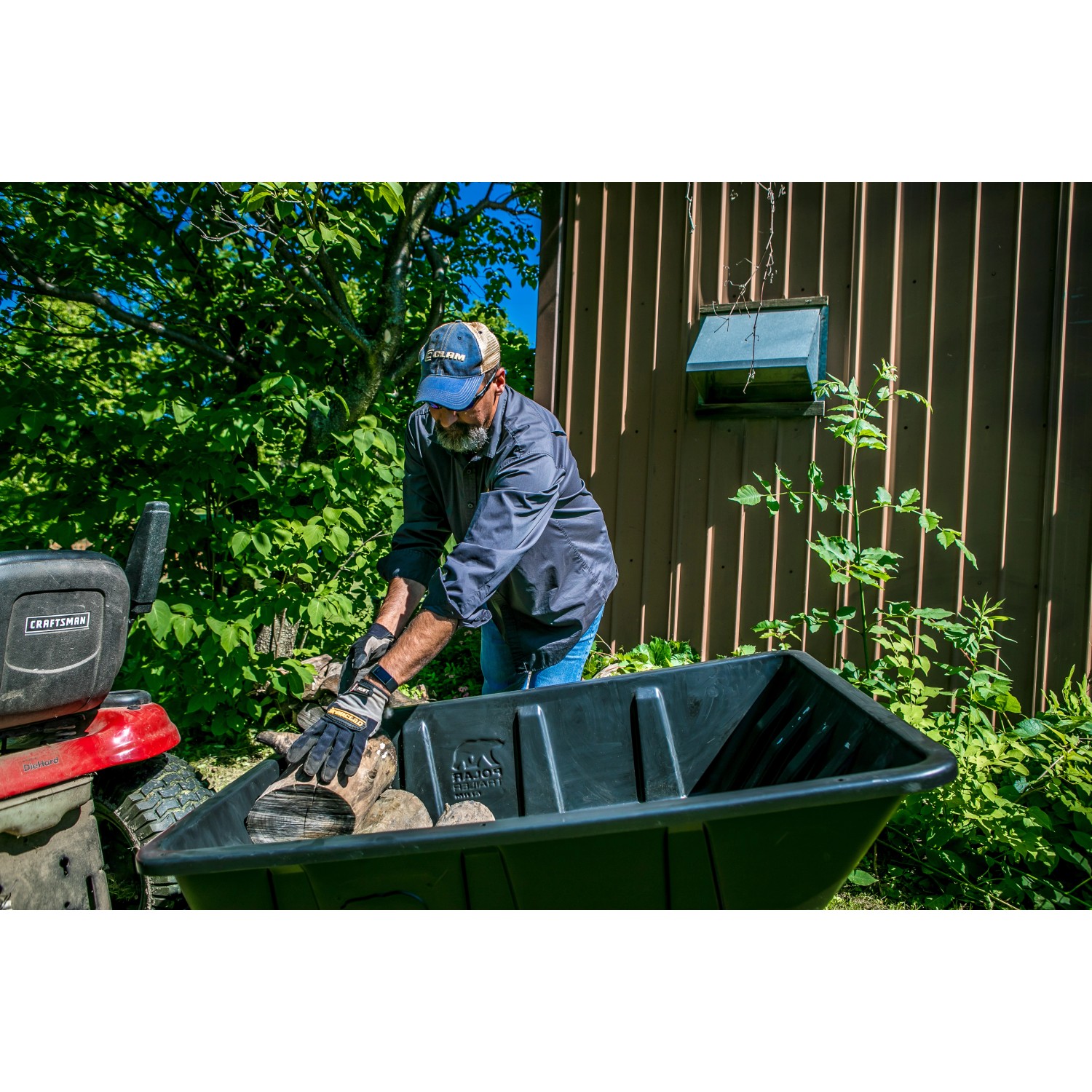Schwarzer Polar Anhänger LG900 Schubkarre mit Holz beladen im Garten.