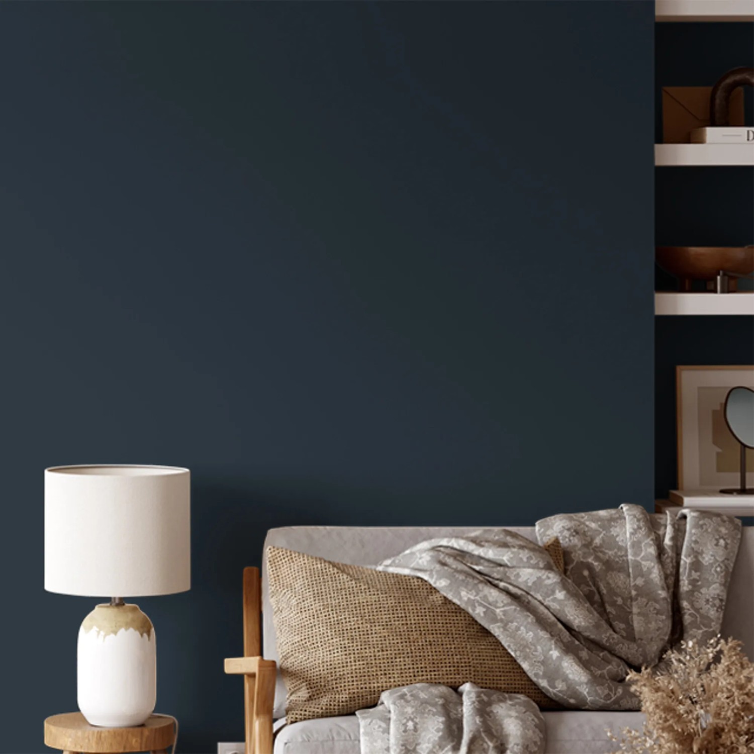 Wand in dunklem Blau mit V&CO Premium-Innenfarbe Mitternachtshimmel, kombiniert mit Lampe und Sofa.