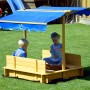 Dobar Sandkasten mit Dach, aus Holz mit blauem Sonnenschutz, Kinder spielen im Garten.