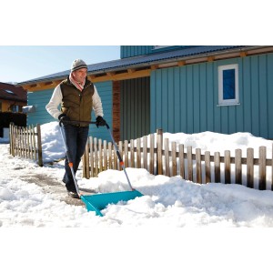 Mann schiebt Schnee mit Gardena Schneewanne 70 cm. Schneeschieber mit Stahlkante für große Flächen.
