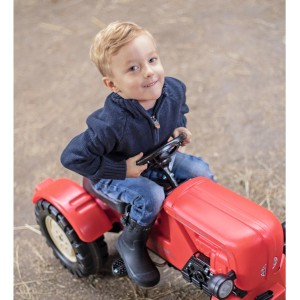 Kind auf rotem BIG Trettraktor Porsche Diesel Junior mit verstellbarem Sitz.
