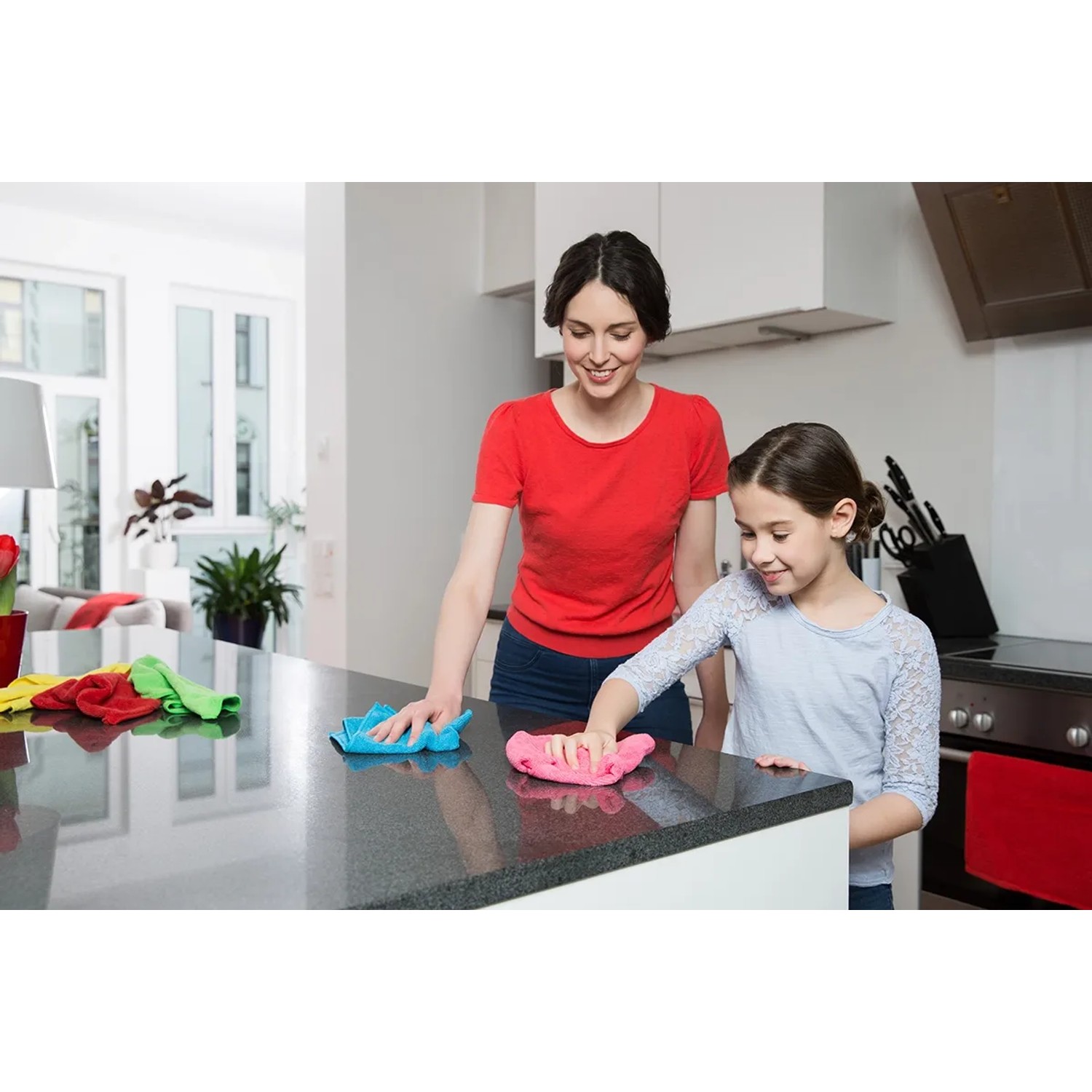 Mutter und Tochter reinigen mit Vileda Mikrofaser Allzwecktüchern eine Küchentheke.