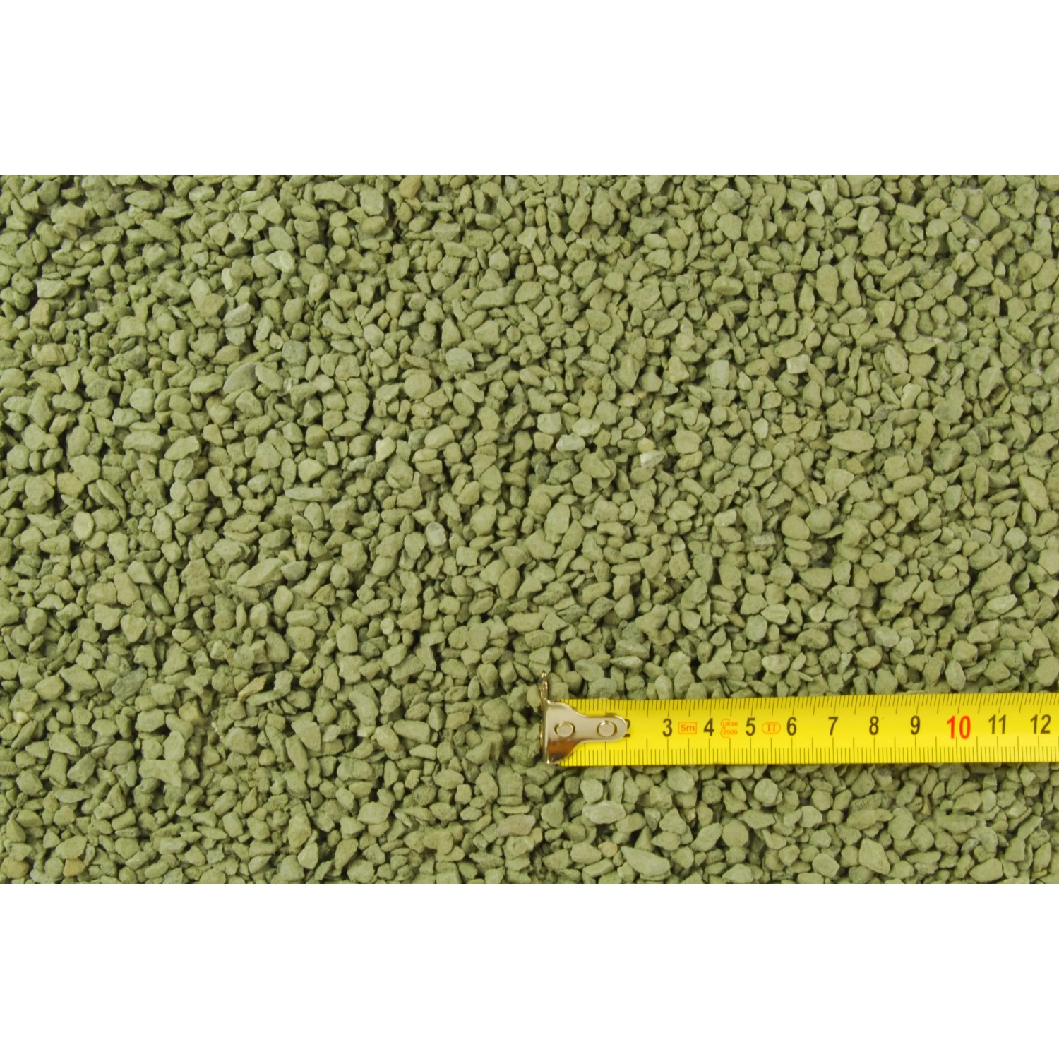 Streu- und Pflastersplitt 2-4 mm, gräulich-grün, mit Maßband zur Größenanzeige.
