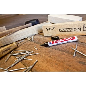 Edding 3000 Permanent Marker, schwarz, auf Werkbank mit Holz und Werkzeug.