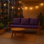 Violettes Setgarden Bankkissen-Set auf einer Gartenbank mit Tisch und Lichterkette.