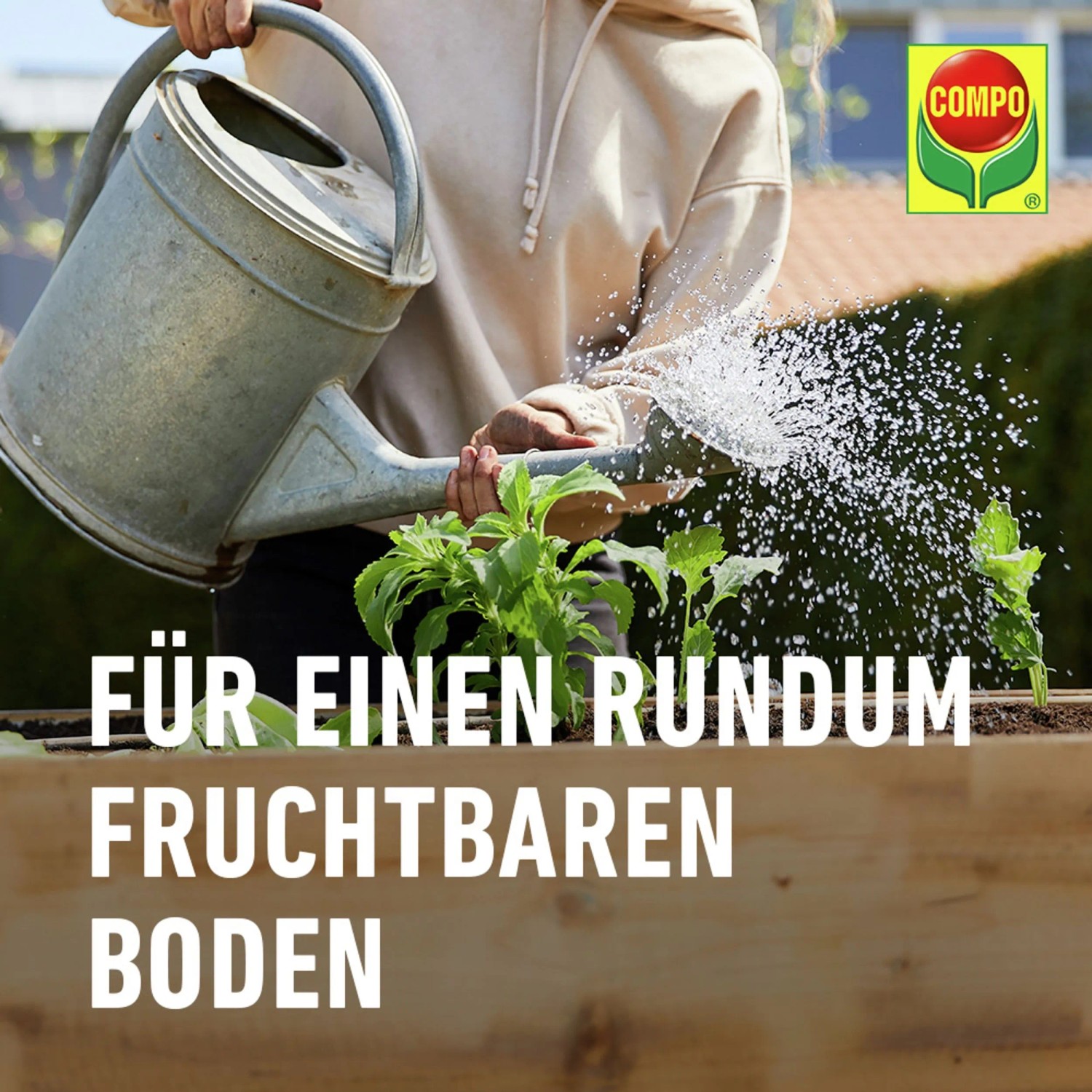 Gärtner bewässert Pflanzen im Hochbeet mit Compo Bio Gärtner-Kompost für fruchtbaren Boden.