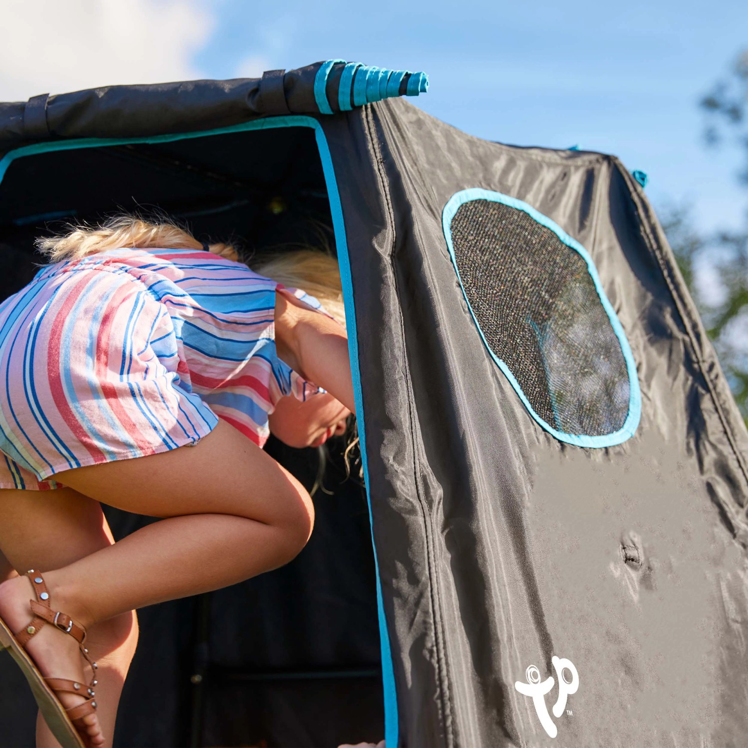 Kind im schwarzen TP Toys Klettergerüst Explorer mit Fenster. Spielturm für Garten.