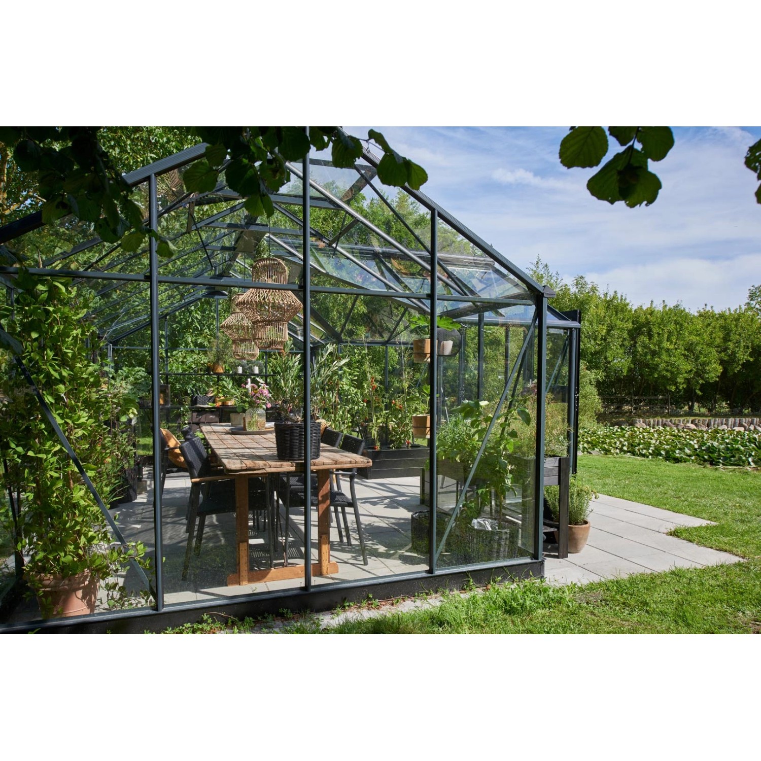 Juliana Gewächshaus Orangerie 21 in Schwarz-Anthrazit mit Tisch und Pflanzen.