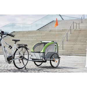 Fischer Kinder-Fahrradanhänger Komfort, grau-grün mit LED-Set, am Fahrrad befestigt.