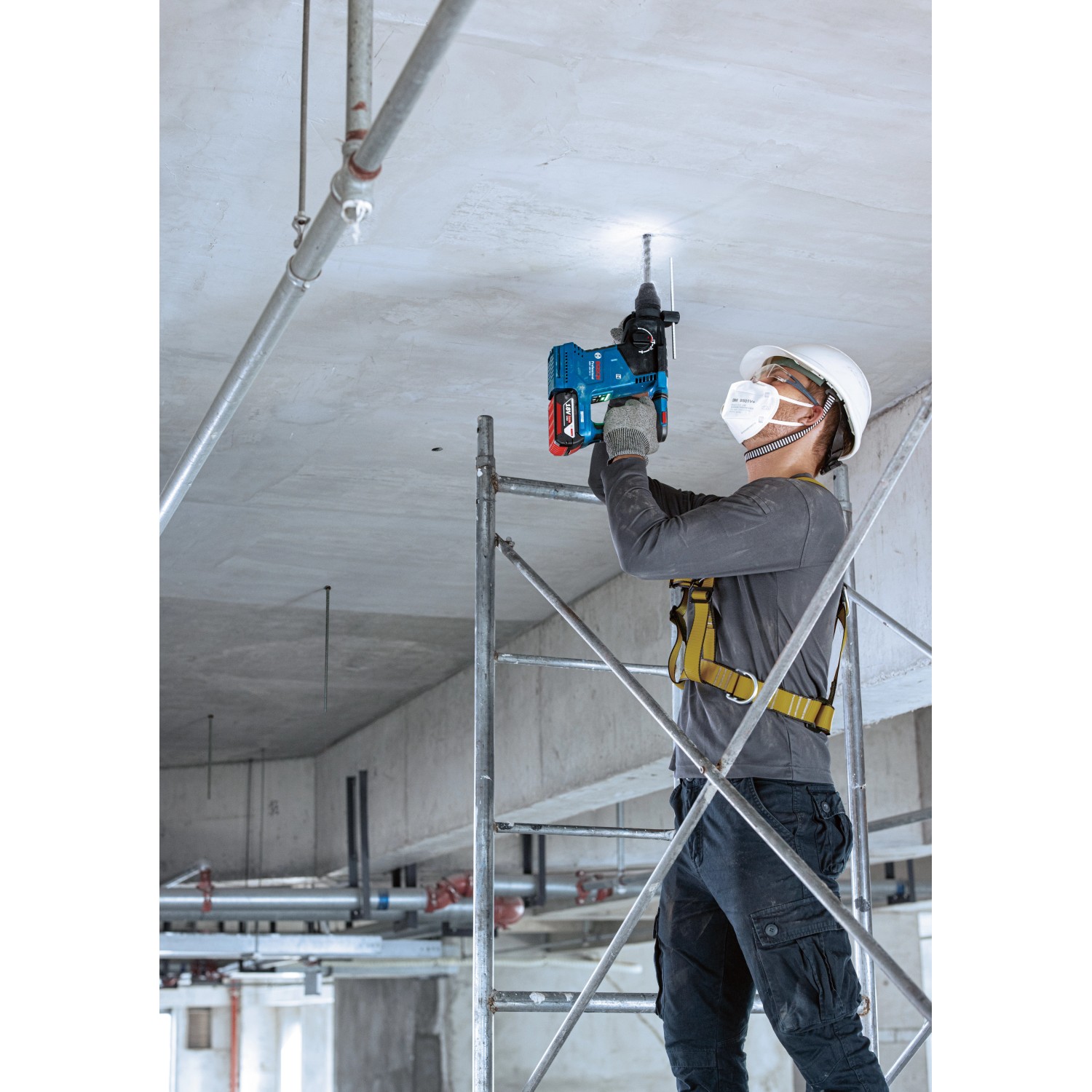 Handwerker bohrt mit dem Bosch Professional Akku-Bohrhammer GBH 18V-24 C in eine Betondecke.