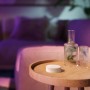 Philips Hue Tap Dial Schalter in Weiß auf Holztisch, smarte Lichtsteuerung.